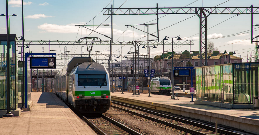 Kuva kesäisestä Tampereen henkilöratapihasta. Kuvassa kaksi laituria, joissa molemmissa seisoo juna.